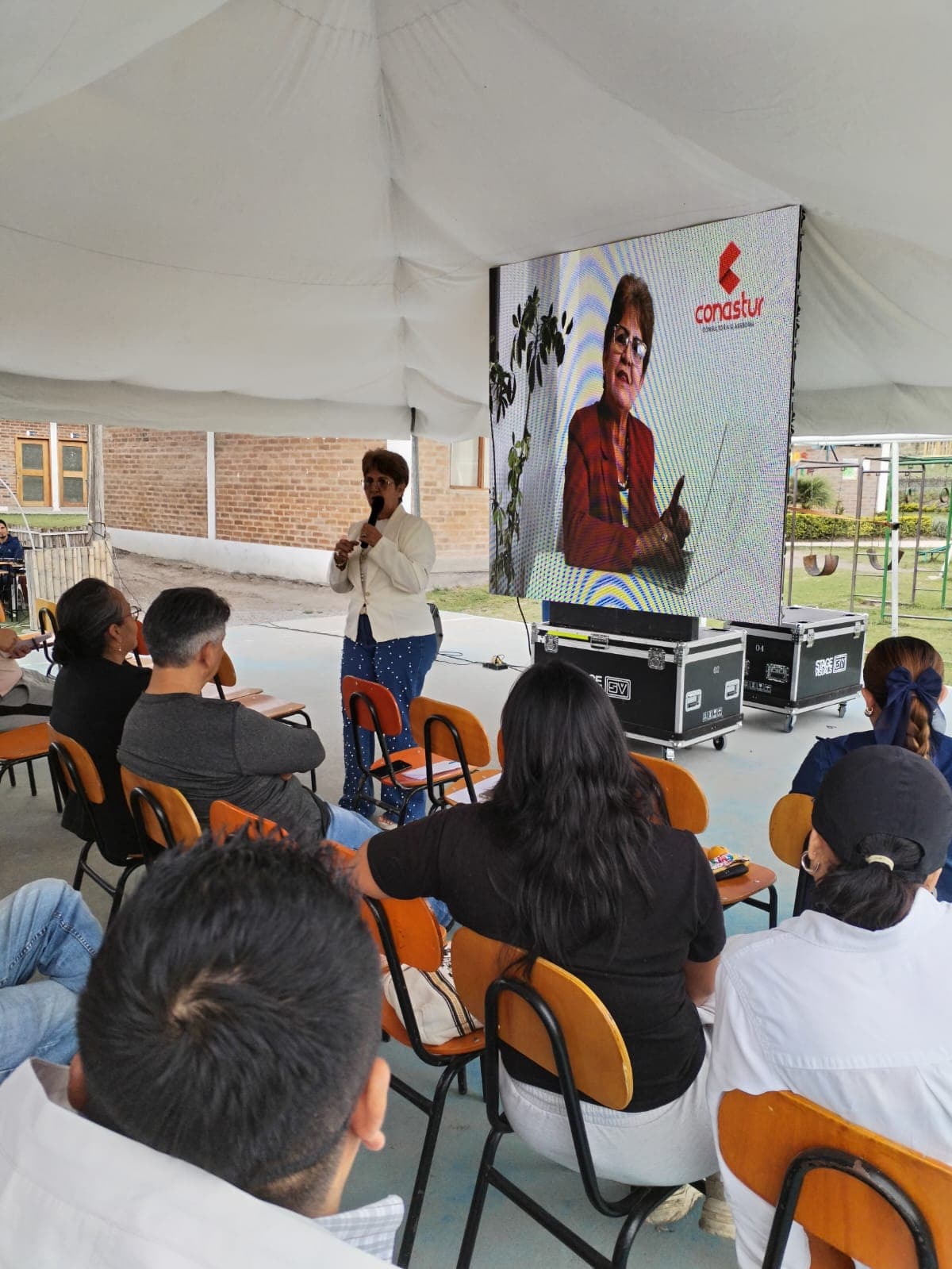 Facilitadora conversando con asistentes durante una presentación